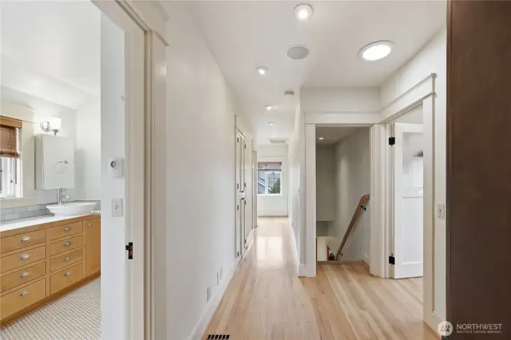 Upstairs hallway, oak wood floors, and down the hall is the 3/4 bath, laundry and third bedroom. On the right is the entrance to the office/den/library, you get to choose how to use this space with a view.