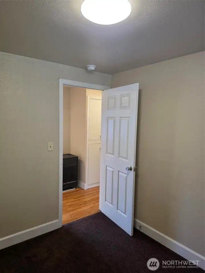 Bedroom three looking out to hallway and gas heater.