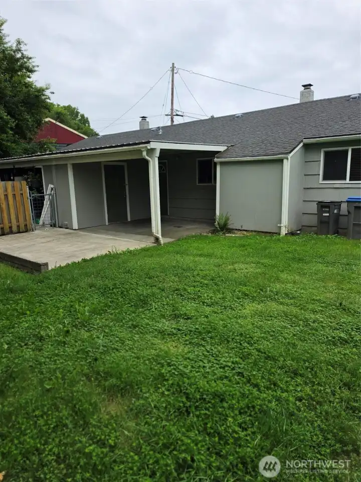 Private back yard and covered patio with washer and dryer in utility room with door off covered patio.  Note fence to left to spearate4 the 2 units back yard.