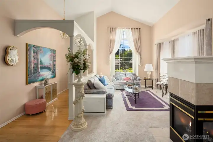 Large windows creating ample natural light and vaulted ceilings.