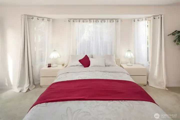 Primary bedroom with large windows creating ample natural light.