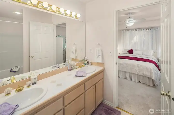 Ensuite bathroom with double vanity, ample storage, and walk in clsoet.