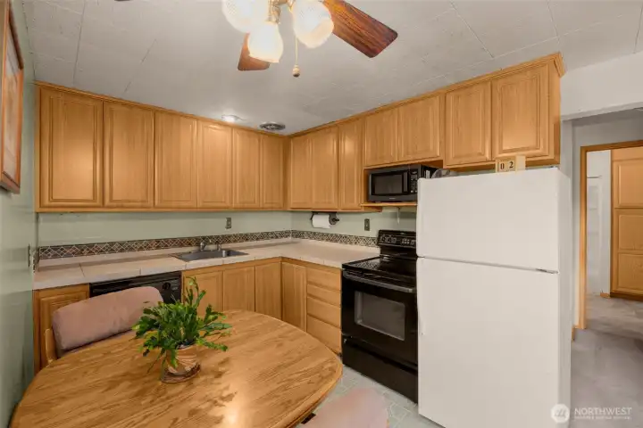 Classic kitchen layout featuring warm wood cabinets and full-sized appliances. Classic kitchen layout featuring warm wood cabinets and full-sized appliances.