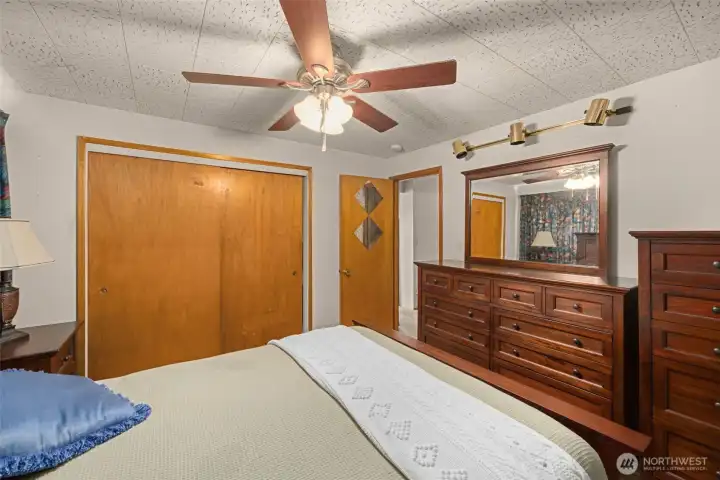 Spacious primary bedroom featuring original wood trim and a wide window wall. Spacious primary bedroom featuring original wood trim and a wide window wall.