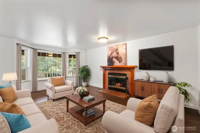 Formal living room offers a wood burning fireplace and bay window.