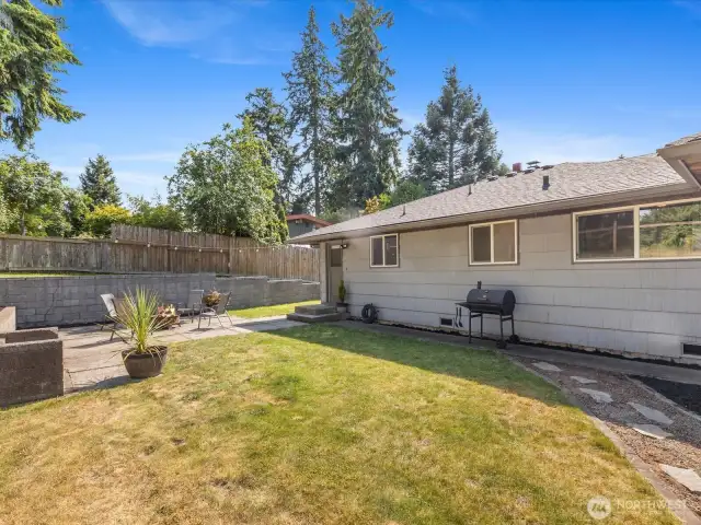 Mature trees provide shade, privacy, and a peaceful backdrop for summer evenings, while the generous lawn invites games of tag, gardening projects, or lazy afternoons in a hammock.