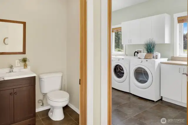 The main level features a half-bathroom and a spacious mudroom/ laundry room