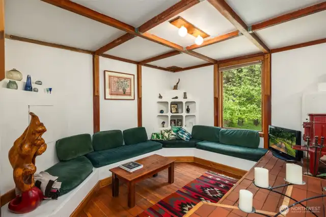 The living room has a boat like feeling with wide plank wood floors, and built-in couch.