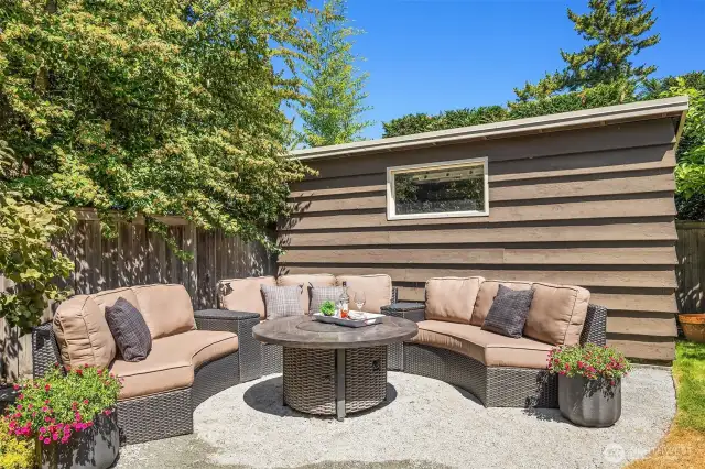 Outdoor fireplace with large storage shed behind