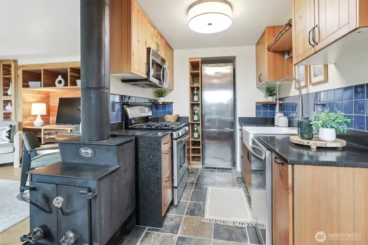 Remodeled kitchen features marble counter, tile floors, stainless appliance, live edge maple wood shelves,  gas range and cedar bump out for the refrigerator and shelving.
