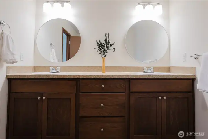 Primary en-suite 5 item bathroom: two sinks, toilet, bathtub with shower
