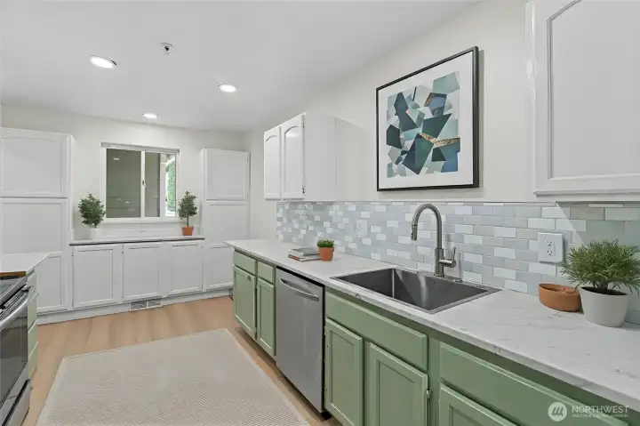 Updated kitchen with ample cabinet storage, wide counters, and an open layout to the dining and living room. Virtually Staged