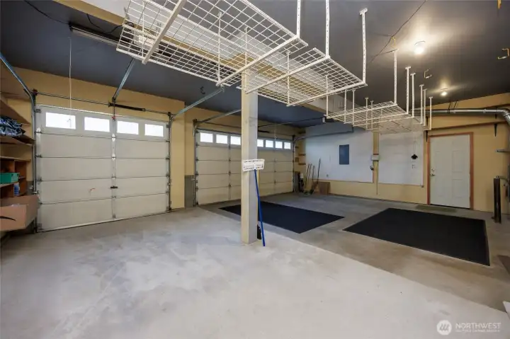 3 car garage w/hang down shelves and door to side yard.