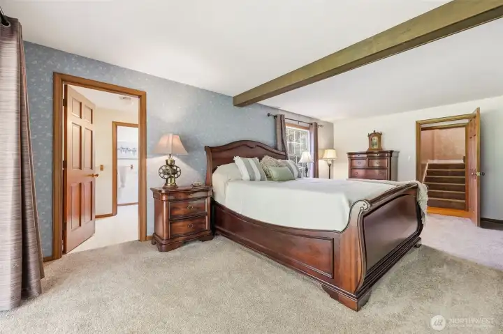 Main level primary bedroom. This features a full primary bathroom and also a slider which leads out to the covered porch.