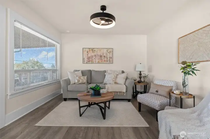 Living room with huge picture window, new flooring, and new paint