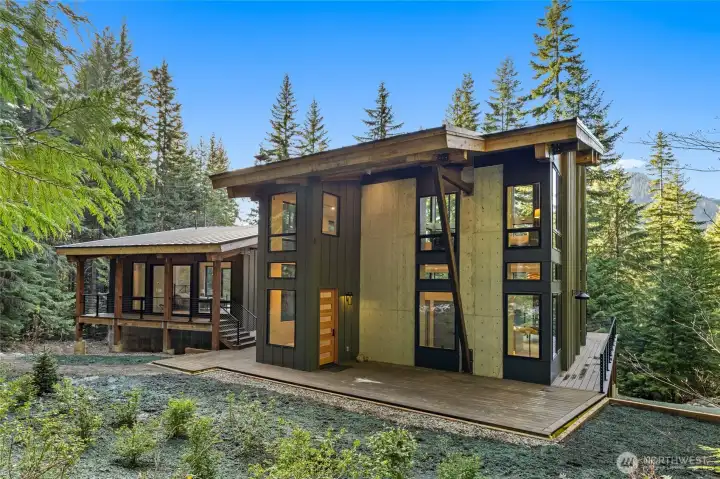 You can see the wrap around porch around the main house and a private deck on the guest home. You can see the trees in the front of the hope bring nature inside. You can also see the mountains in the front of the home. If desired, you can limb some trees, you could see mountains with a beautiful view.