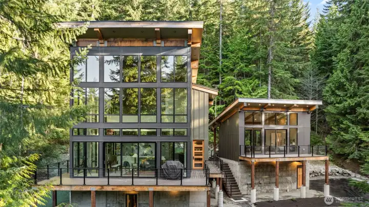 A great view of the main home and guest house. They are situated on the lot to take in all the enchanting forest around you.