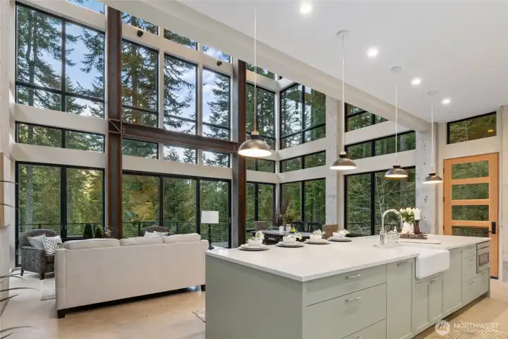 View of the kitchen with custom cabinets, open to the living room and dining room You can see a door to the right that allows another access point to the wrap around deck.