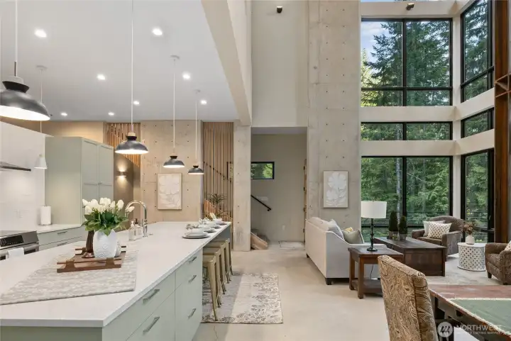 Here is a view of the kitchen open to the living space and there is a 2nd story door to the wrap around deck on the south side of the home as well as on the north side. View of stairs going up to the primary bedroom.
