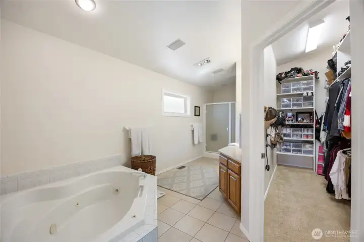 Master bath with jetted corner soaking tub and walk in closet.