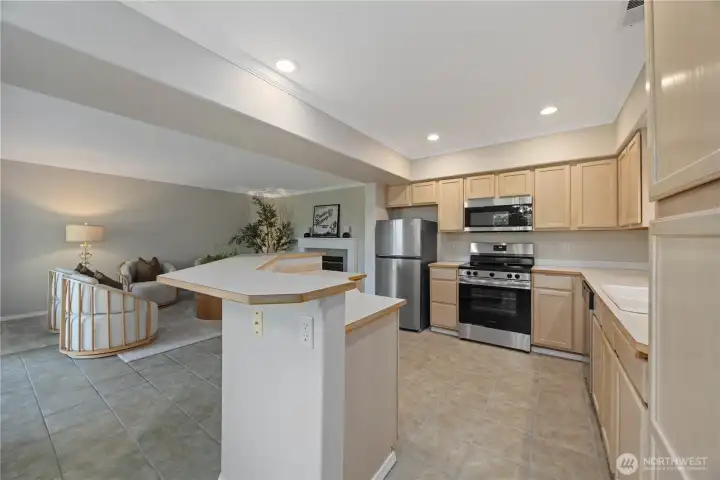 Beautifully updated kitchen featuring new stainless steel appliances, abundant cabinetry, and expansive counter space designed for both everyday living and entertaining. The open-concept layout flows seamlessly into the dining and living areas, while large windows bring in natural light and create a bright, welcoming atmosphere. Clean finishes and modern touches complete this functional and stylish kitchen space.