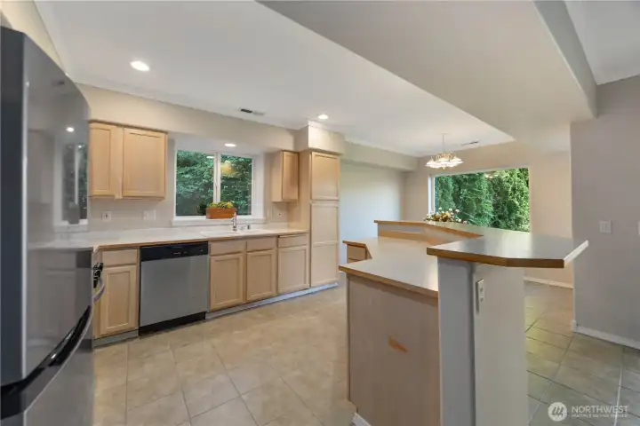 Beautifully updated kitchen featuring new stainless steel appliances, abundant cabinetry, and expansive counter space designed for both everyday living and entertaining. The open-concept layout flows seamlessly into the dining and living areas, while large windows bring in natural light and create a bright, welcoming atmosphere. Clean finishes and modern touches complete this functional and stylish kitchen space.