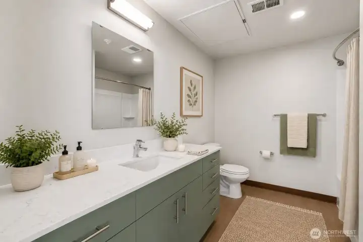 Large bathroom with plenty of storage and counter space. Quartz countertops and LVP flooring continued in the bathroon. Virtually staged Large bathroom with plenty of storage and counter space. Quartz countertops and LVP flooring continued in the bathroon. Virtually staged