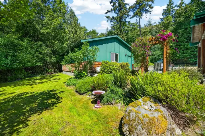 From the backyard by the deck, features another outside room with a beautiful arch and outdoor seating From the backyard by the deck, features another outside room with a beautiful arch and outdoor seating