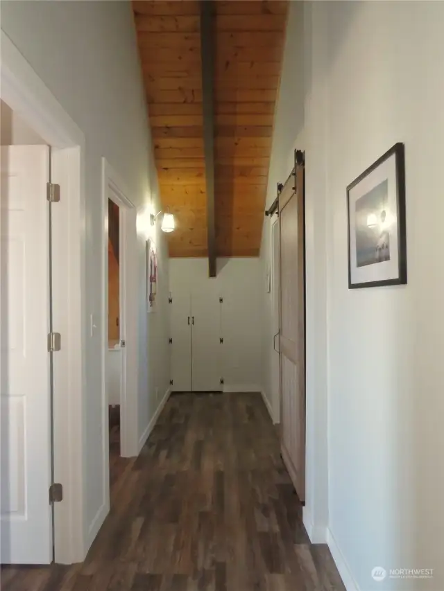 HALLWAY IS GORGEOUS WITH VINYL PLANK FLOORING AND THE WOOD VAULTED CEILINGS!