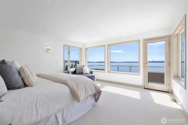 Wake up to sweeping 180-degree views through a stunning wall of windows in the primary bedroom.
