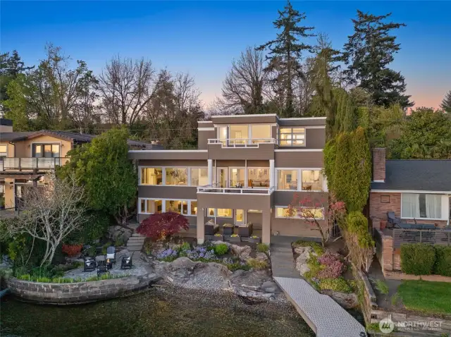 Designed for outdoor living, this property features two expansive decks, two patios—including a covered retreat—play spaces, a lush yard, and a 110' dock for endless lakefront enjoyment.