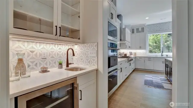 Centrally located butler's pantry boasts a wet bar, beverage fridge and adjacent to that is a large walk-in pantry.