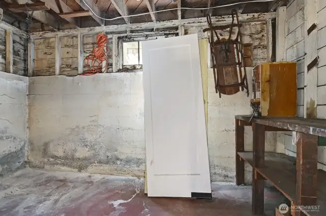 Unfinished basement storage room behind garage