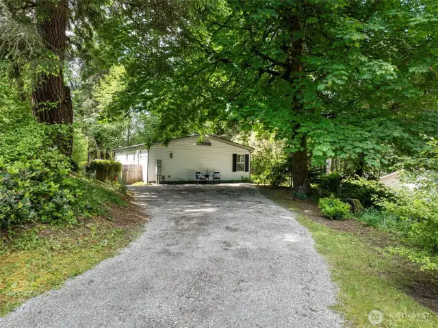 The home is surrounded by greenery, is set back from the street that circles the lake, and has ample parking.