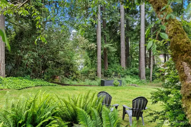 A gentle sloped lawn boarders the lake, greenbelt, and garden area.