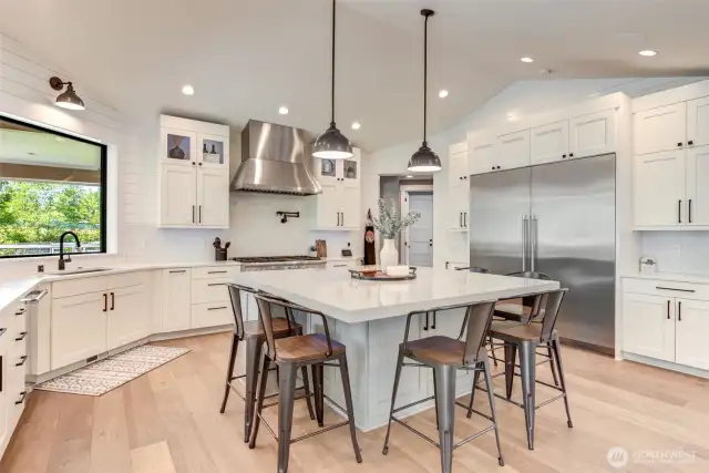 Different angle of kitchen. Professional chef stove & hood. Big oversize refrigerator and freezer.