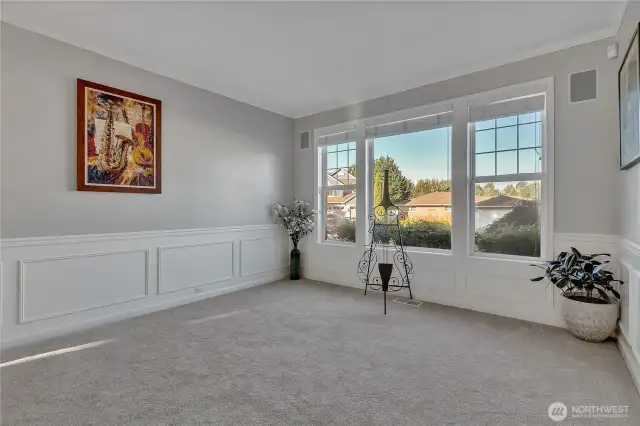 The spacious living room features designer colors and molding throughout, and large windows enhancing usability and ambiance.