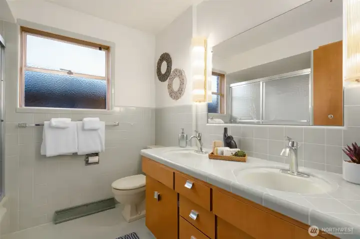 Main bath on the main floor with original tile and cabinetry. The tile and grout is in incredible condition.