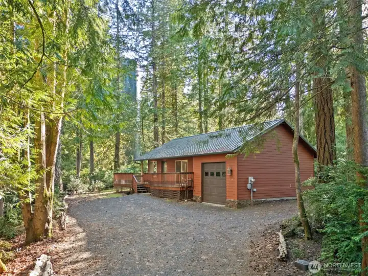 Driveway with lots of parking.  Home has partial wrap deck, dog run from deck (screened for small animals), cedar plant siding & metal roof.