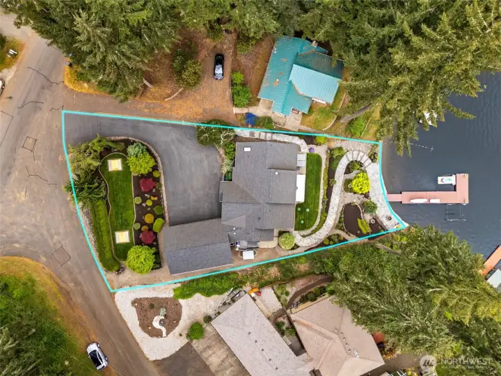 From above, you can really appreciate how much this property packs into its beautifully planned quarter-acre footprint. The terraced landscaping, expansive outdoor living spaces, waterfront access and carefully designed transitions between each level all work together to create this incredible sense of flow from the street all the way down to the shoreline. Situated in the Long Lake Country Club neighborhood, the home captures that relaxed resort-style energy where everyday life starts feeling a little more like vacation mode. There are spaces here for entertaining, quiet mornings, lakeside adventures, sunset gatherings and everything in between. And the best part is how livable it all feels.