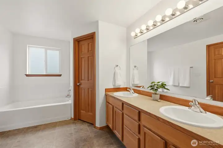 5 piece Primary Bathroom, Dual Sinks, bathtub, shower, and  closed toilet room