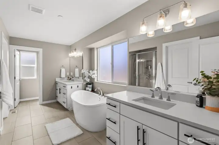 With a double vanity and dual closets, this en-suite bathroom meets every couple's storage needs.