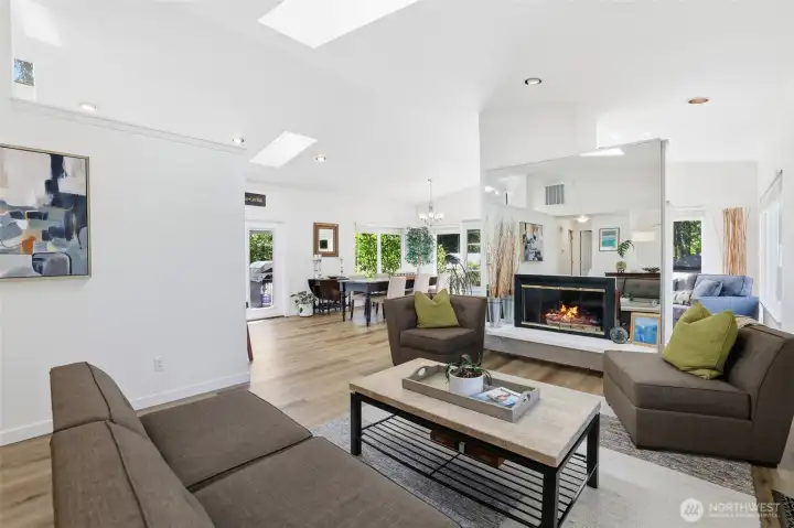 The living, dining, and sitting area feature soaring vaulted ceilings, expansive picture windows, and skylights that flood the space with natural light, creating a bright, open, and inviting atmosphere throughout. The living, dining, and sitting area feature soaring vaulted ceilings, expansive picture windows, and skylights that flood the space with natural light, creating a bright, open, and inviting atmosphere throughout.