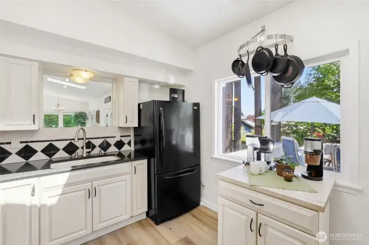 A large window provides wonderful natural ventilation, while the perfectly placed pot rack adds charm and functionality, giving the kitchen a warm French-inspired feel. A large window provides wonderful natural ventilation, while the perfectly placed pot rack adds charm and functionality, giving the kitchen a warm French-inspired feel.