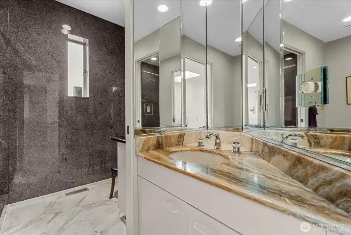 Bathroom with expansive vanity space, mirrored storage, and a walk-in shower. Bathroom with expansive vanity space, mirrored storage, and a walk-in shower.