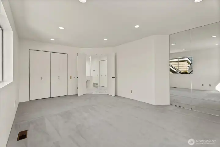 Spacious bedroom with mirrored closet storage and a flexible layout. Spacious bedroom with mirrored closet storage and a flexible layout.