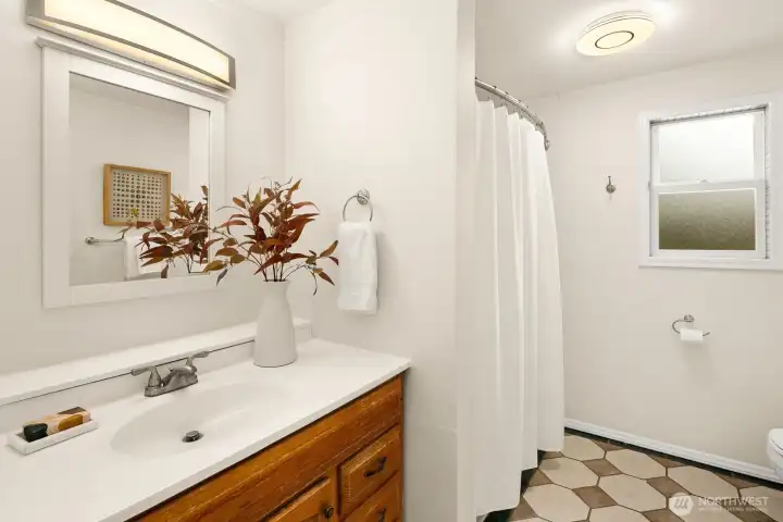 Full bath with ceramic tile floor and new updated lighting