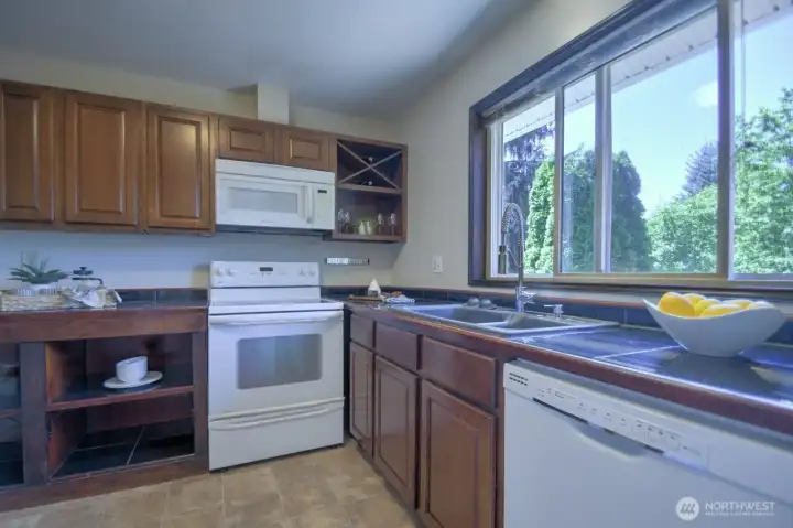 Stylish and functional kitchen with cherry cabinets that allow for the attractive display of your service wear and kitchen necessities.