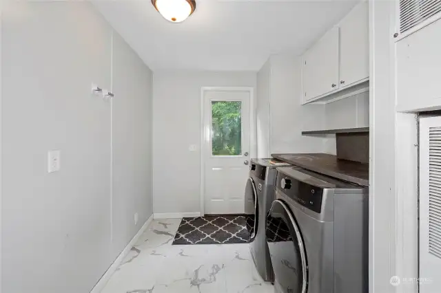 Laundry room leads out to back deck. Ample storage and could add a folding table. New flooring here and in the bathrooms.