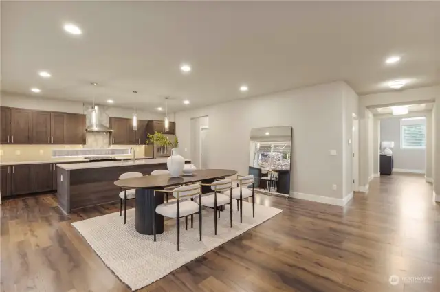 The open concept living area offers a formal dining space, perfect for entertaining. Gleaming laminate flooring expands throughout the main level